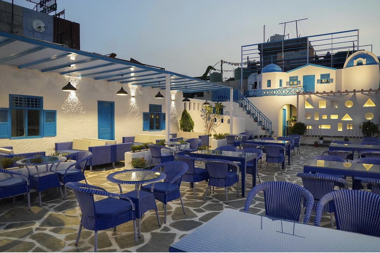 Norwang Cafe rooftop with Greek-inspired blue and white architecture at dusk